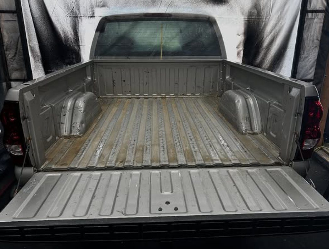 A bare, rusted truck bed before coating